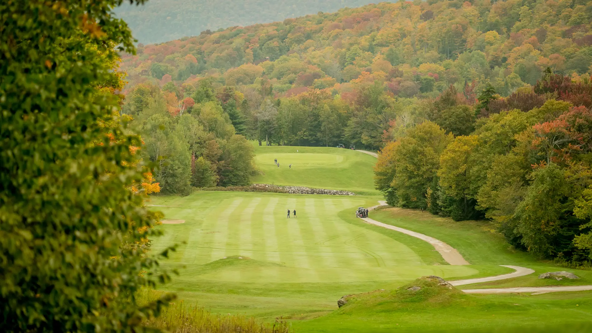 Golfers playing through Vermont's fall landscape